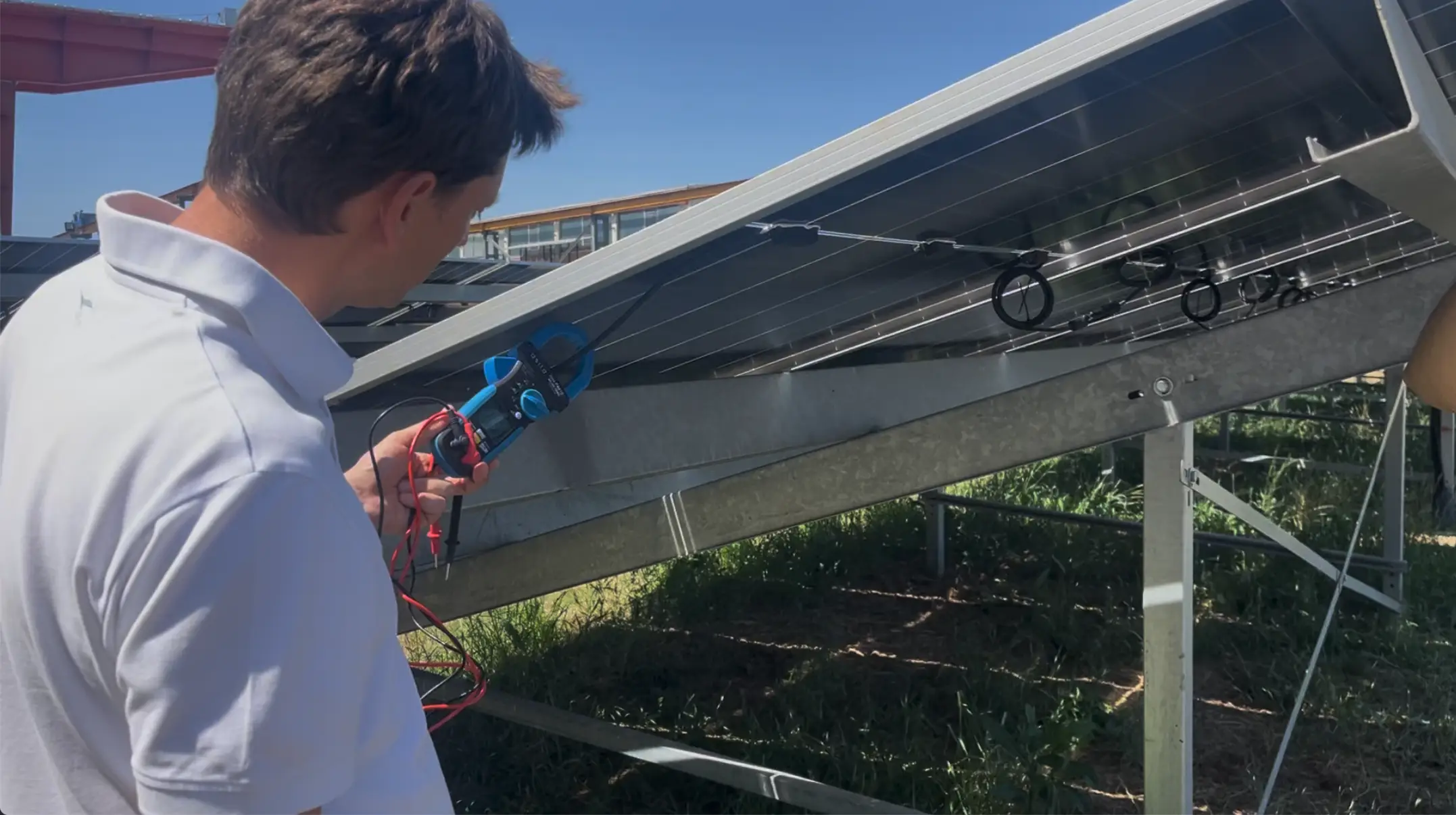 verifica-stringhe-impianto-fotovoltaico-pinza-amperometrica Tecnico Crea Energia misura la corrente di una stringa fotovoltaica con pinza amperometrica sul retro dei moduli